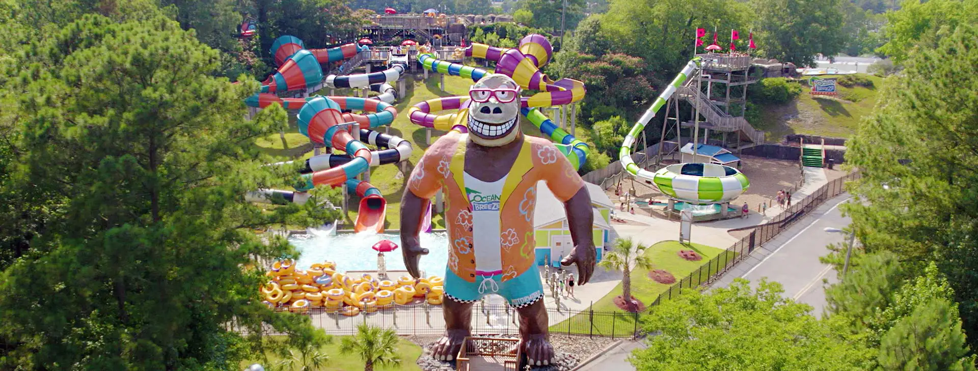 Hugh Mongous mascot standing in front of water slides