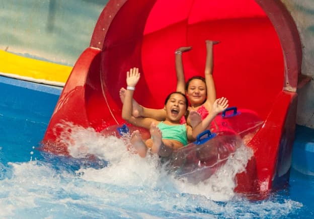 Two girls coming out of a water slide